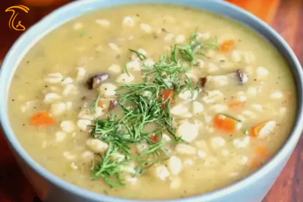 عکسی از یک کاسه آبی آسمانی رنگ است که در آن سوپ جو می‌باشد.