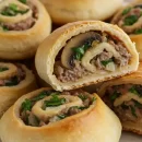 عکسی از طرز تهیه رولت گوشت چرخ کرده و قارچ که با خمیر دست ساز خانگی یا خمیر آماده هزارلا درست شده است. با یک طرز تهیه رولت گوشت رستورانی همراه ما باشید.