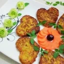 عکسی از یک دیس سفید که درون آن غذای گیاهی کوکوی قارچ مجلسی (کوکو قارچ) قلبی شکل با فاصله به صورت دایره ای درون آن قرار دارند.